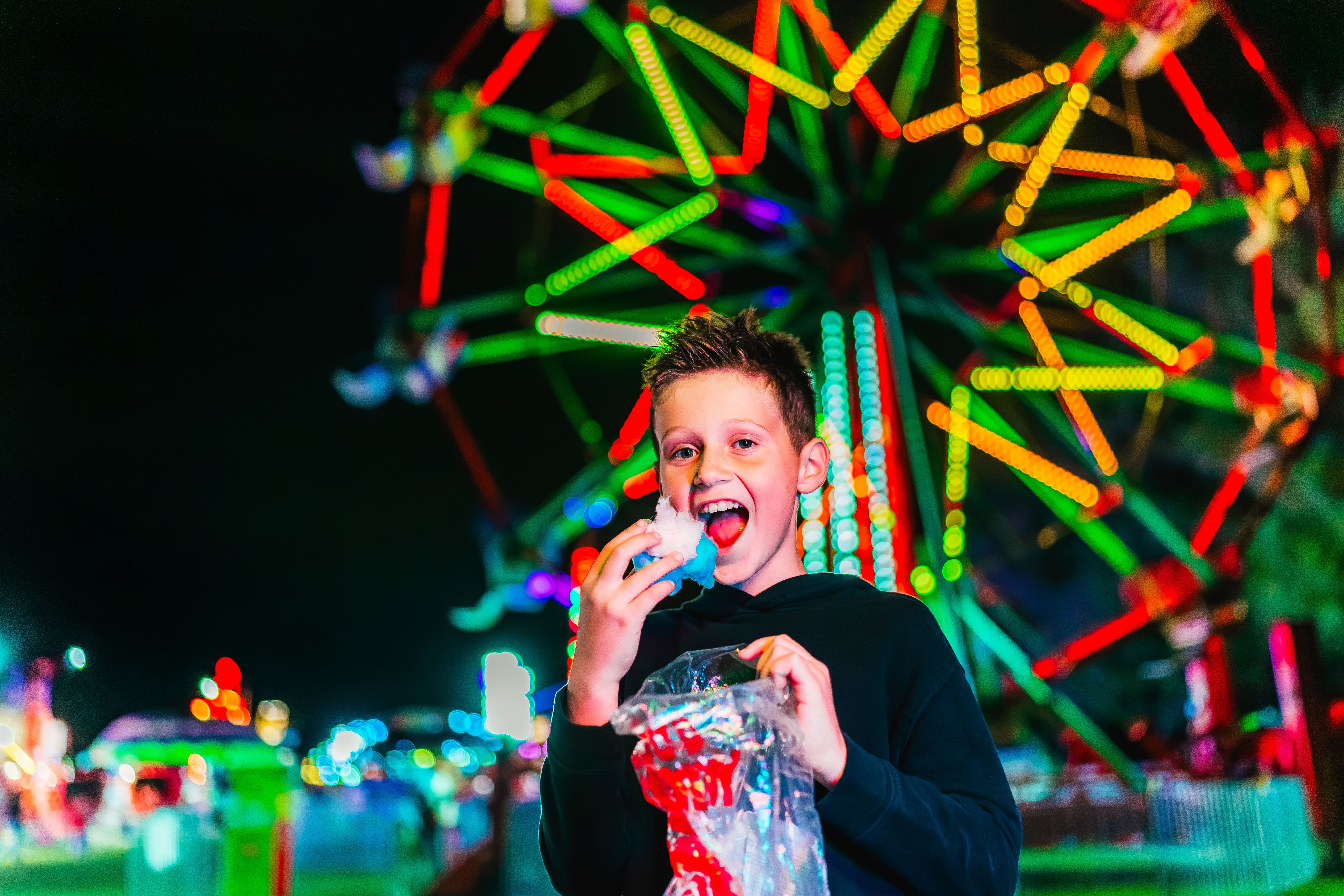 Boy in front of a ferris wheel 