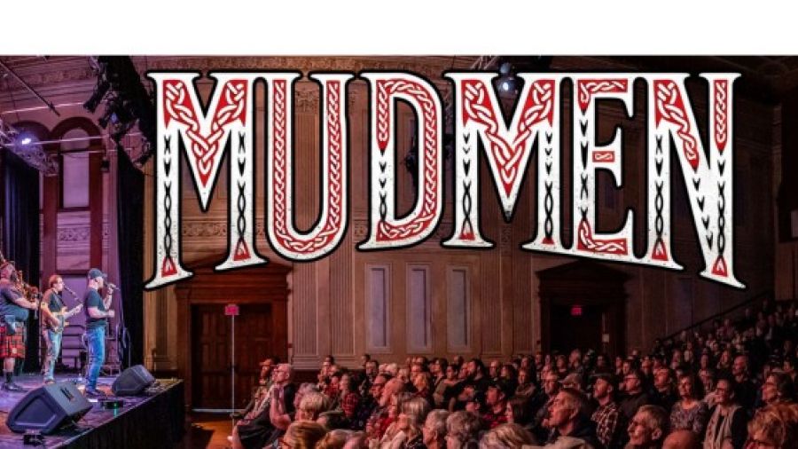 Concert promotional banner for Mudmen featuring the band performing on stage in front of a seated audience, with large stylized “Mudmen” text displayed prominently above.