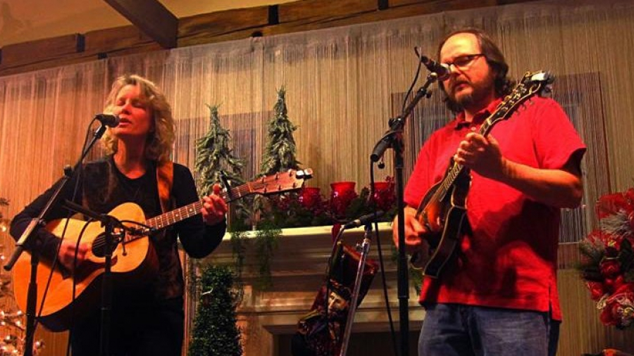 Man and woman playing guitar and singing 