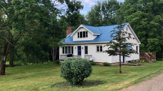 Blue and white cottage in forest