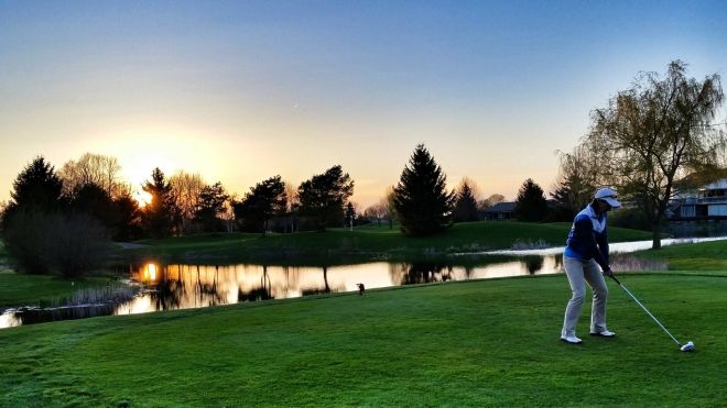 a man hitting a ball at Pine Knot at sunset
