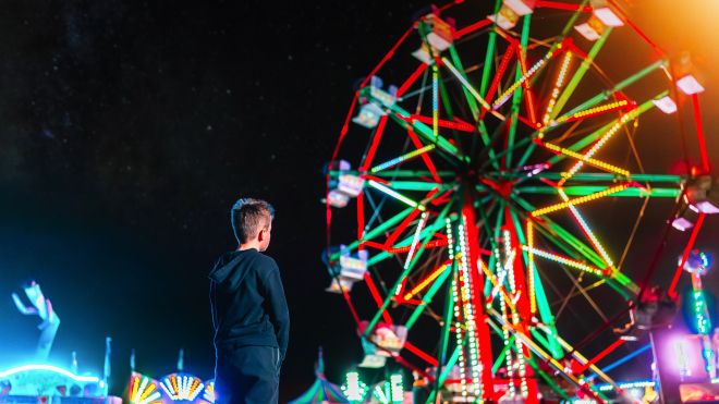 Kid looking at ferris wheel 