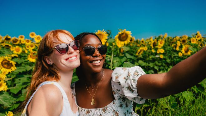 Two women in a sunflower field