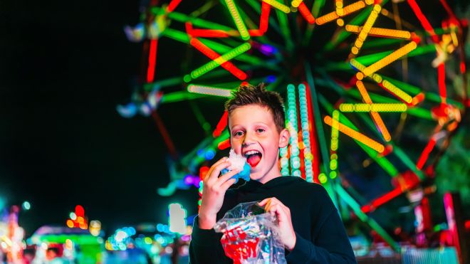 Boy in front of a ferris wheel 