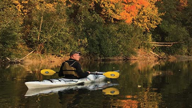 Man canoeing in the fall
