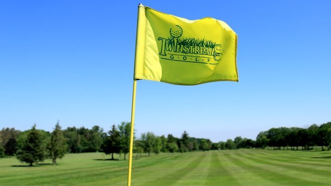 a yellow flag with green lettering on the course with the Twin Streams logo
