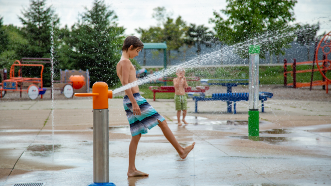 little boy playing in the splash pad a the komoka wellness centre