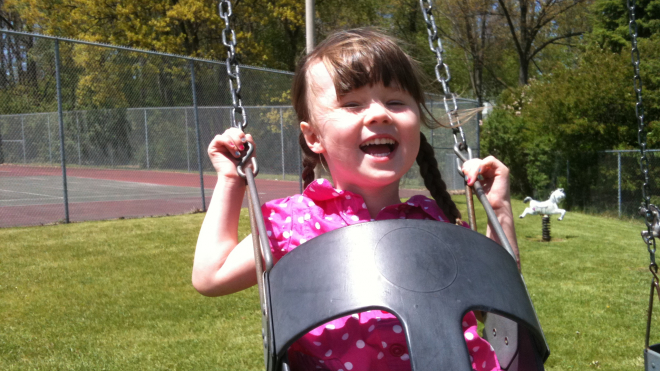 girl playing on a swing 