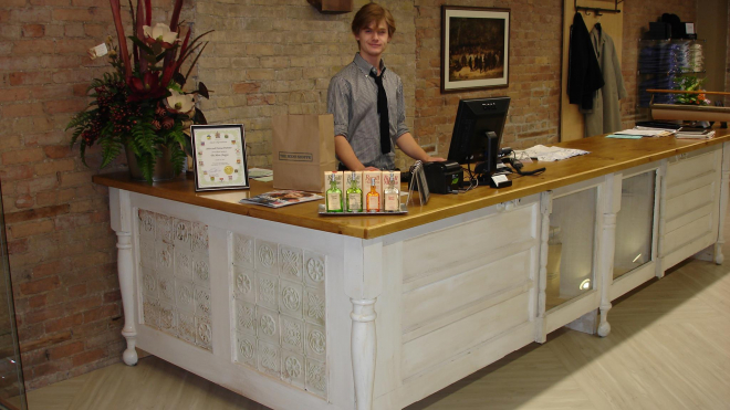 a young boy standing behind a desk as a cashier 