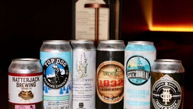 A selection of craft beers photographed on a dimly-lit wooden table