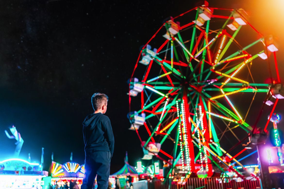 Kid looking at ferris wheel 