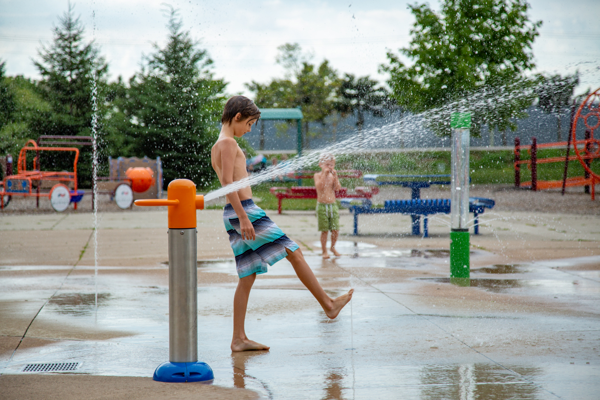 little boy playing in the splash pad a the komoka wellness centre