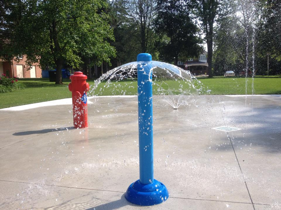 Mount brydges lions splash pad feature; blue base and tower spewing water in 360 motion