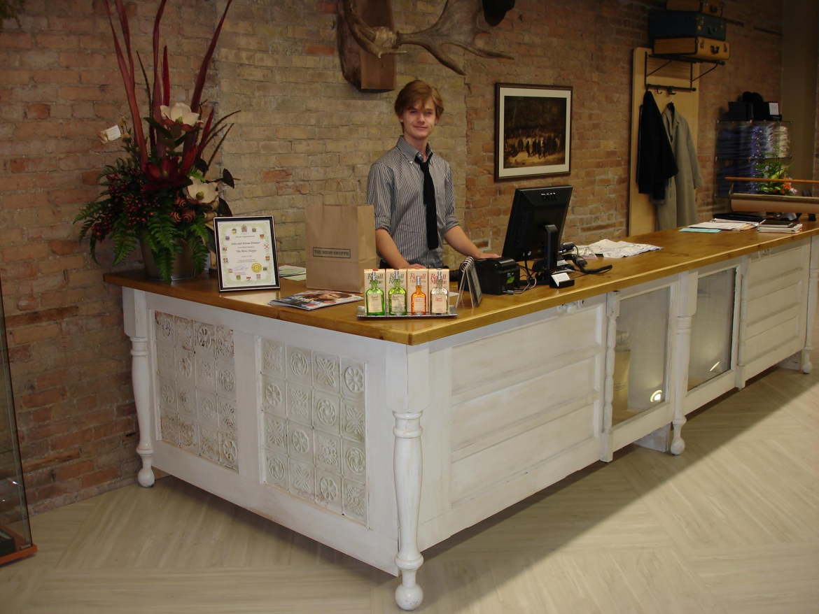 a young boy standing behind a desk as a cashier 