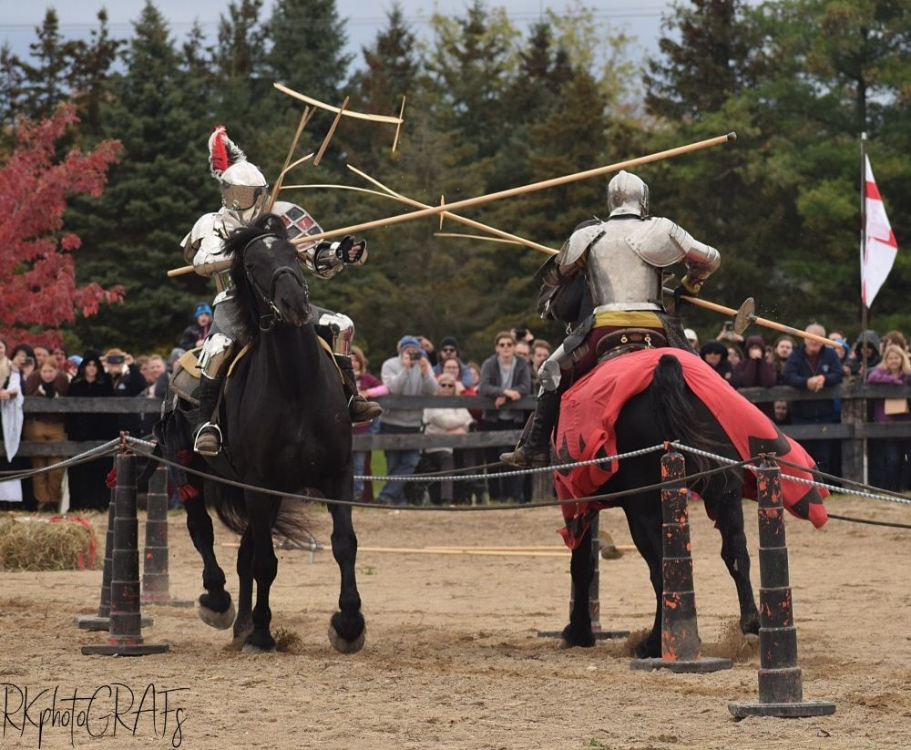 Two men in medival jousting gear poke eachother with sticks