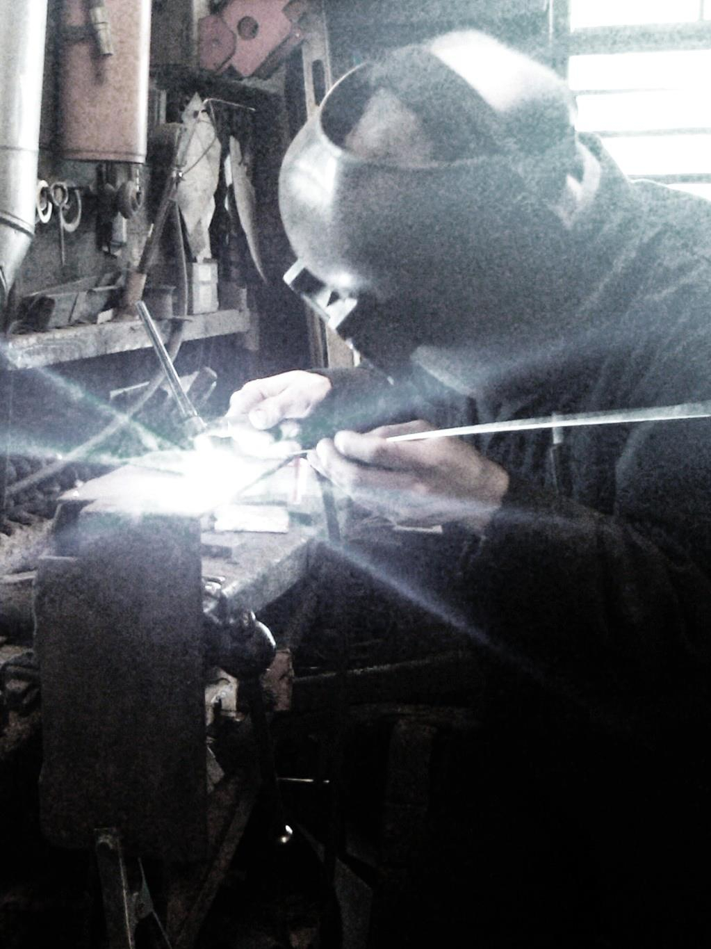 a man welding in a shop 