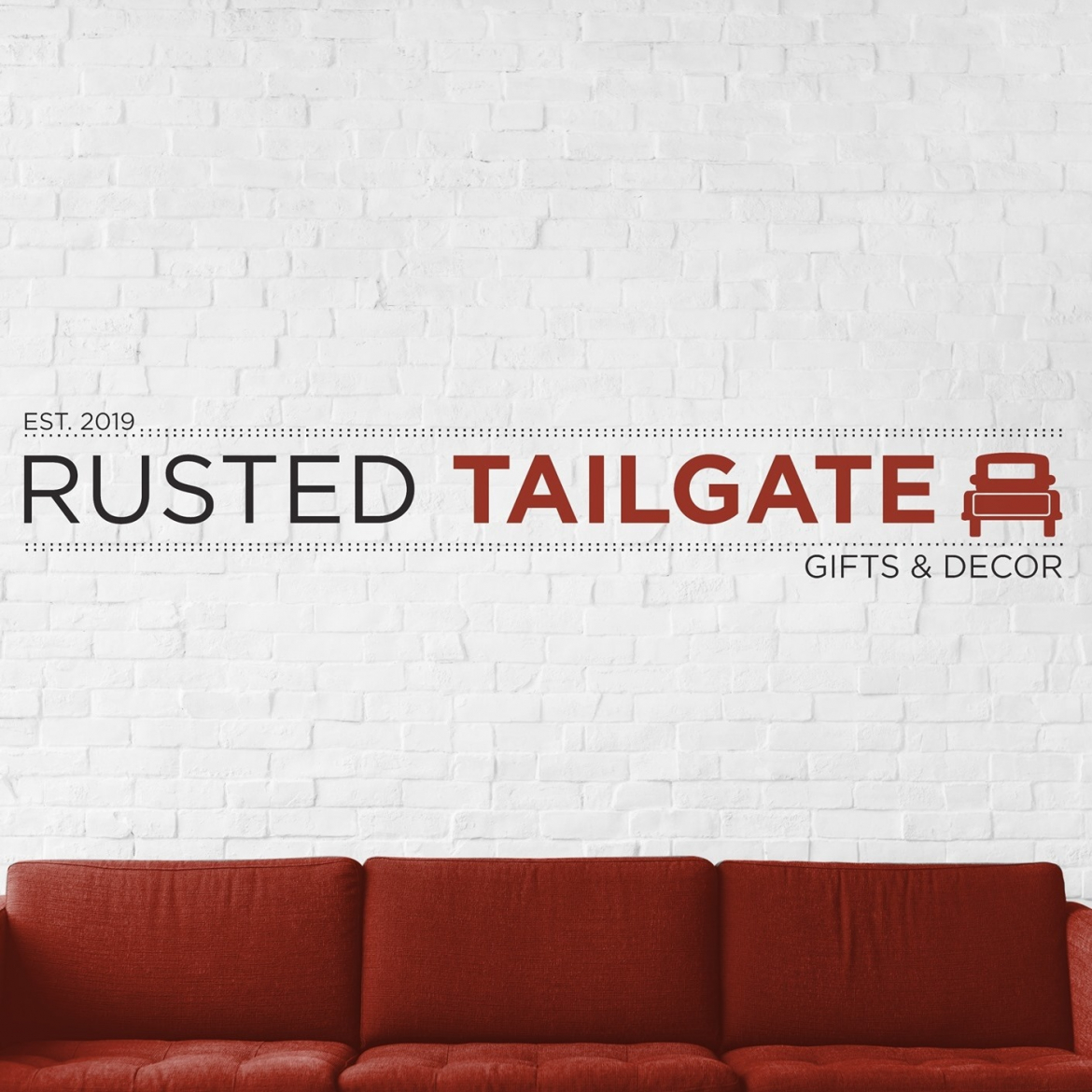 rusted tailgat wall sign with red truck graphic beside it over a auburn coloured couch 