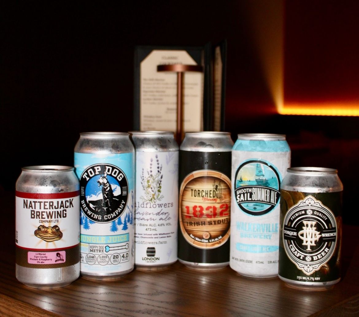 A selection of craft beers photographed on a dimly-lit wooden table