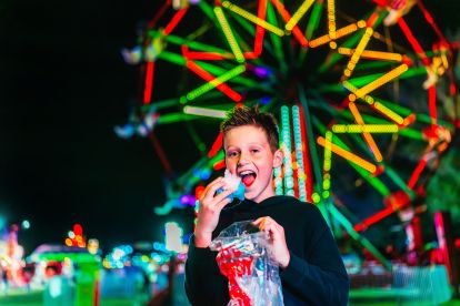 Boy in front of a ferris wheel 